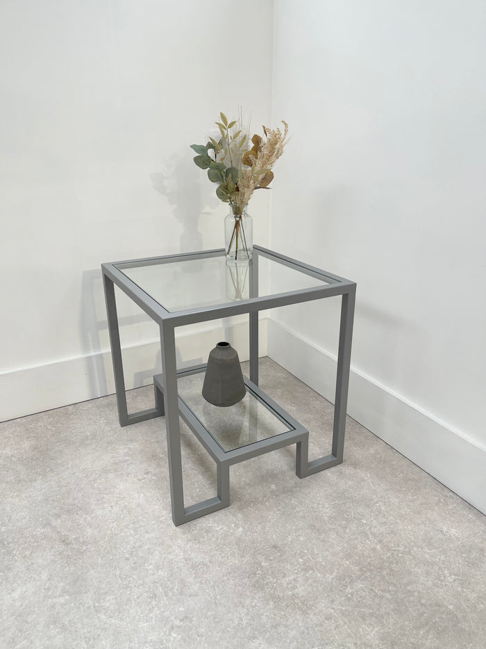 light grey metal side table with glass shelves