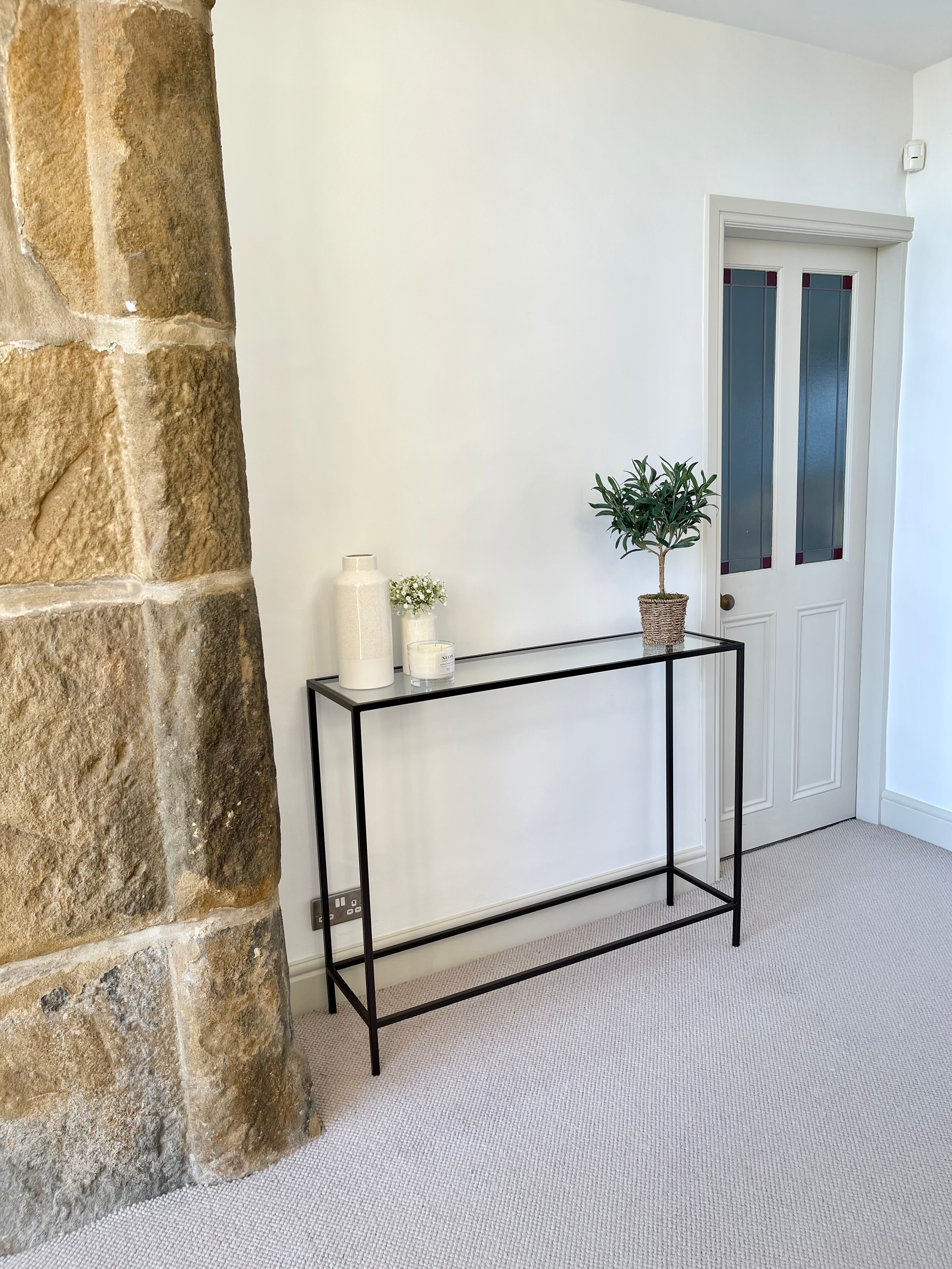 sleek thin black metal side table in a hallway