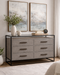 Gray dresser with black metal frame in a room with abstract art and decor.